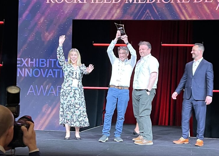 tomas holding up the nhia award
